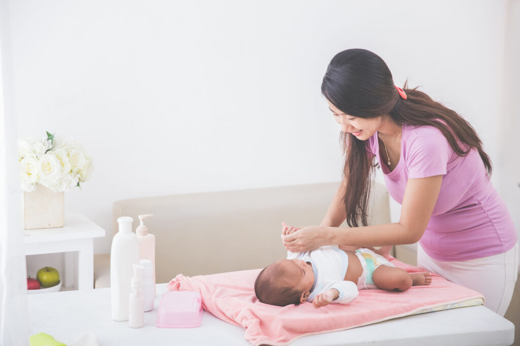 48377051 - portrait of a mother put on some clothes to her baby